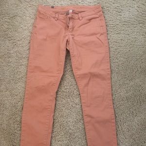 Peach colored skinny pants.